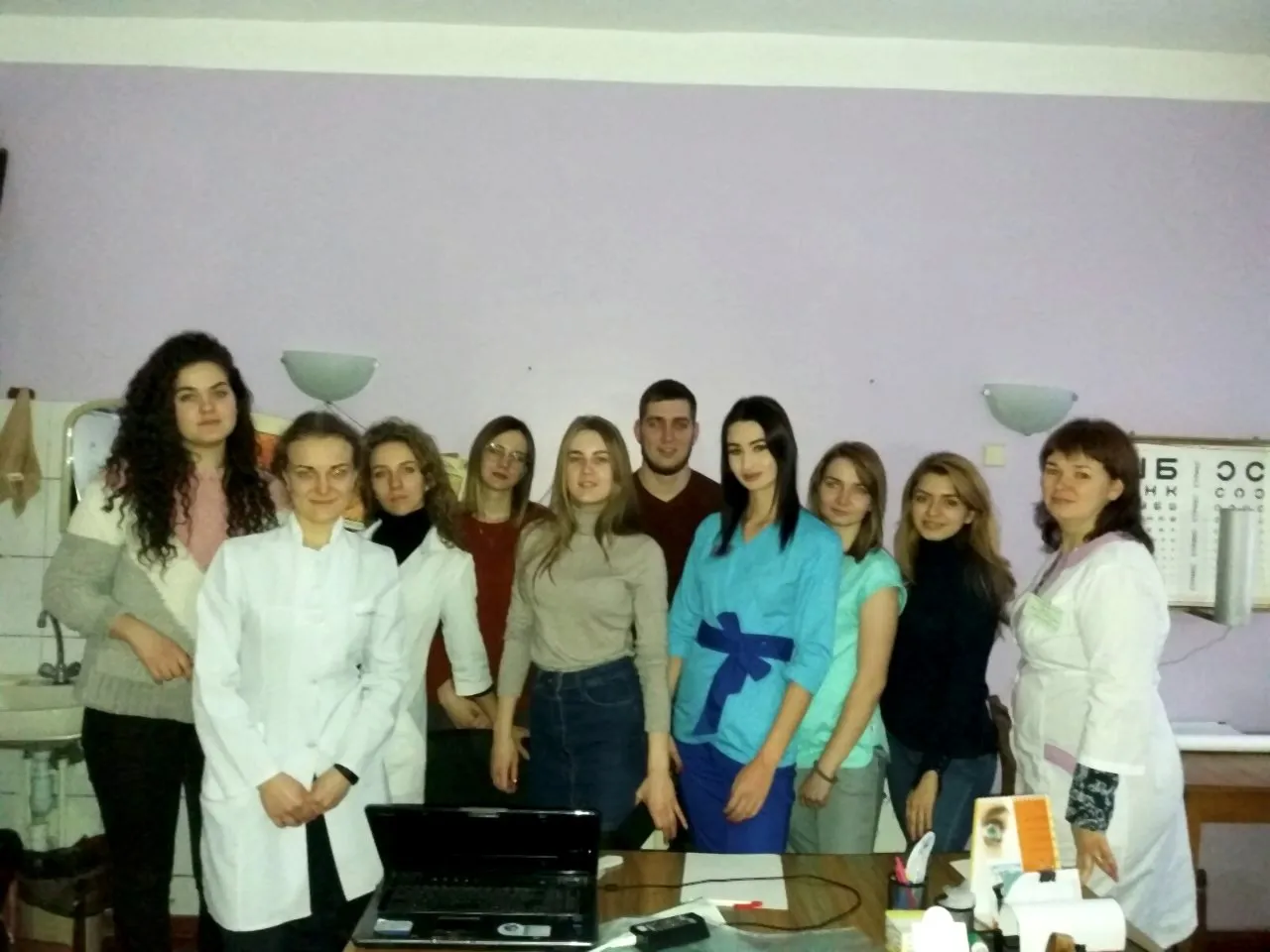 Наталія Гарькава зі студентами після заняття в кабінеті з таблицею для перевірки зору